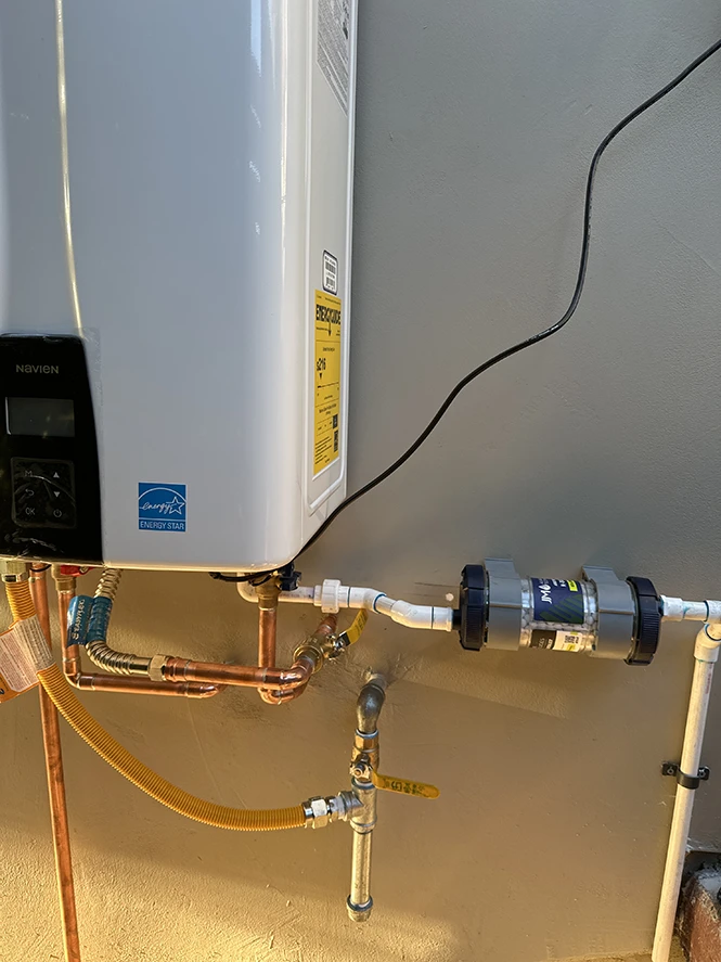 JJM condensate neutralizer installed on a residential tankless water heater system.